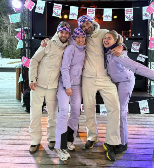 Het SnowBite-team in skipakken op het podium van een festival in de sneeuw
